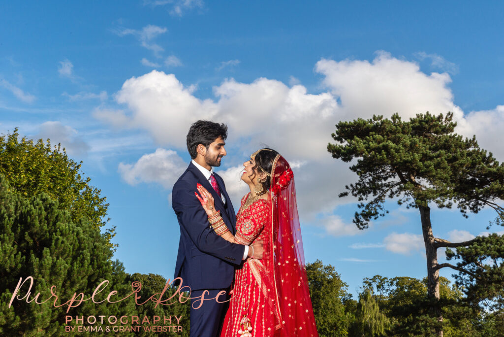 Photo of a bride and groom in front of blue sky on their wedding day in Milton Keynes