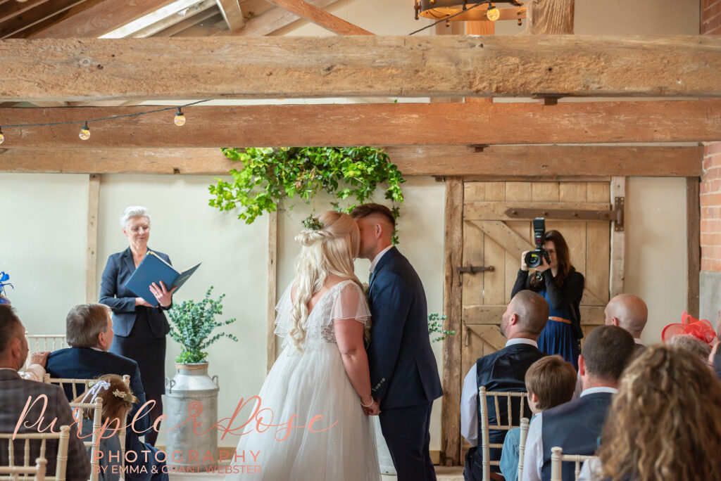 Photo fo bride and grooms first kiss during their ceremony day in Northampton