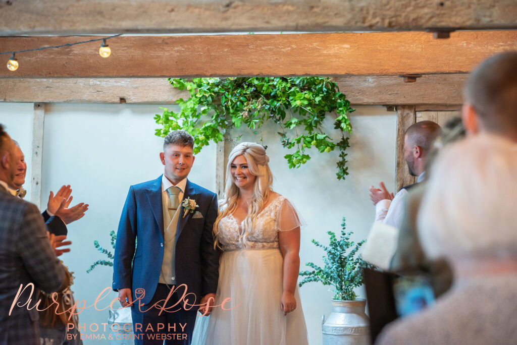 Photo of bride and groom preparing to leave their wedding ceremony on their wedding day in Northampton