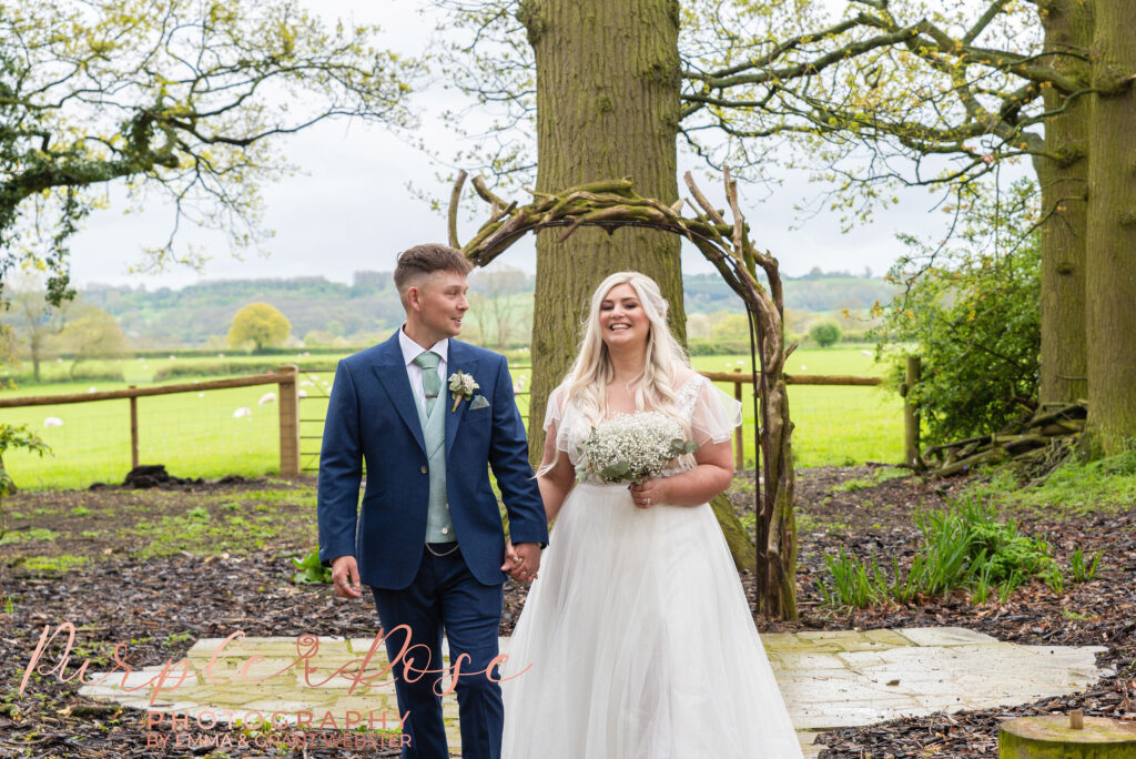 Bride and groom walking hand in hand on their wedding day in Northampton