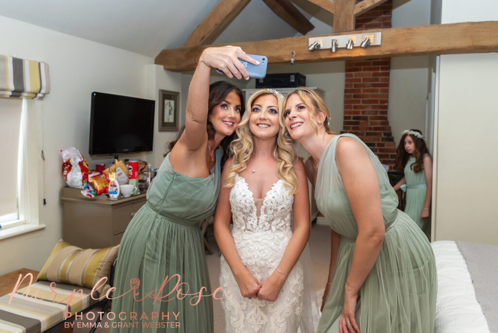 Photo of a bride taking a selfie with her bridesmaid at her wedding in Northampton
