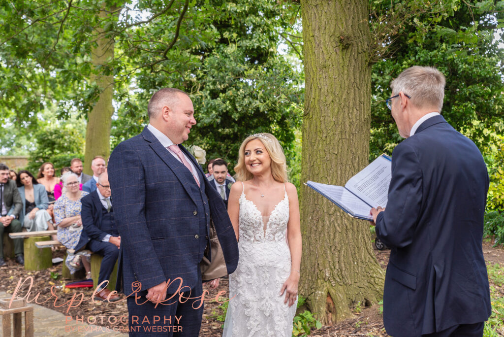 Photo of a bride and groom stood during their outdoor wedding ceremony at Park Farm Northampton