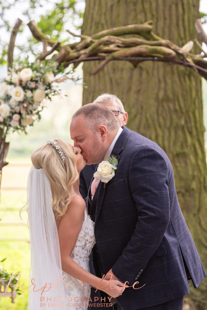 Photo of brde and grooms first kiss on their wedding day in Northampton