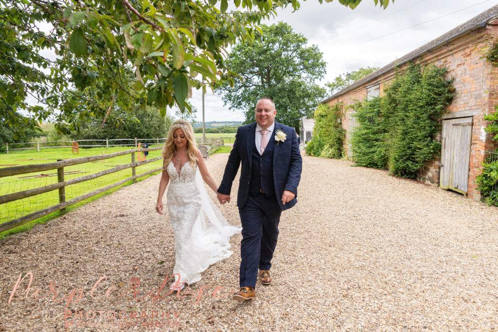 Photo of bride and groom walking han din hand on their wedding day in Northampton