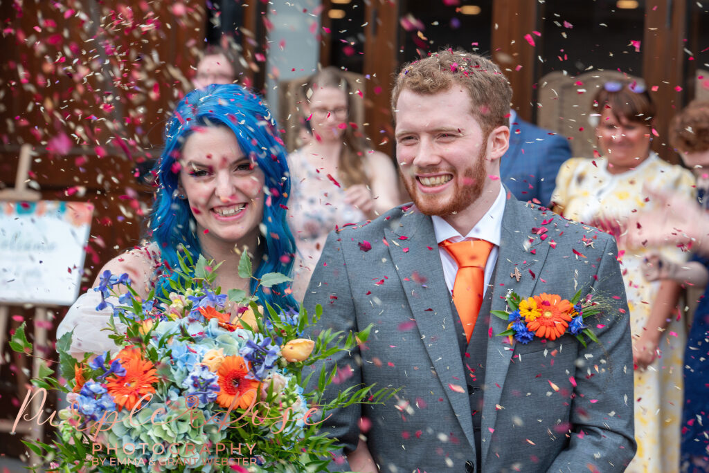 Photo of bride and groom being showered with confetti outside their wedding venue in Milton Keynes