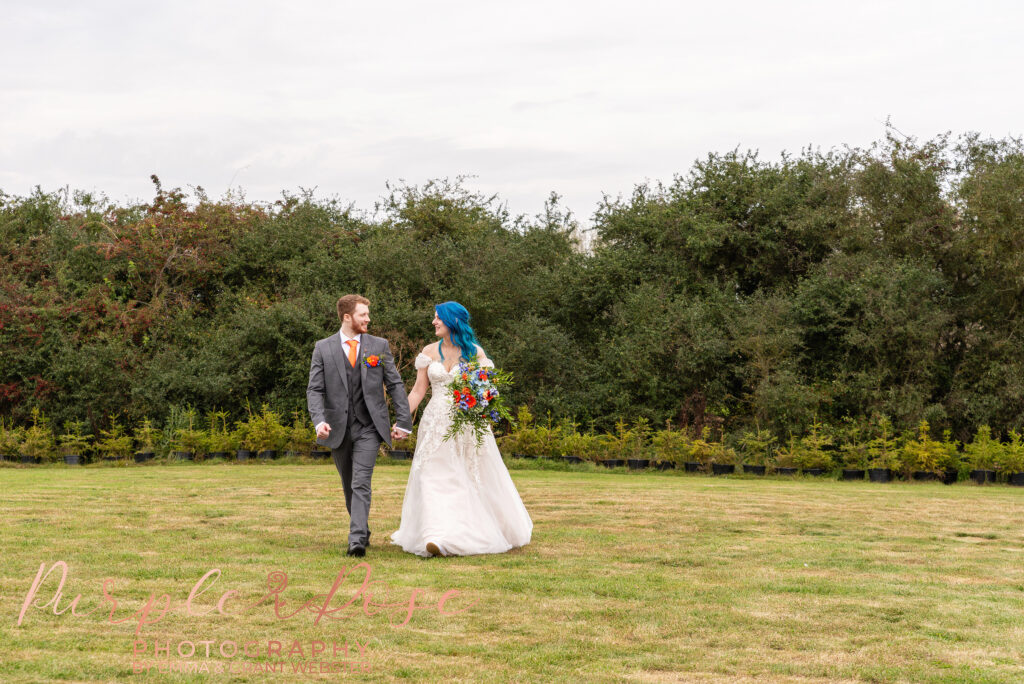 Photo of bride and groom walking hand in hand on their wedding day in Milton Keynes