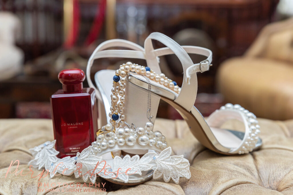 Photo of brides shoes and jewellery arrnage on an armchair on the brides wedding day
