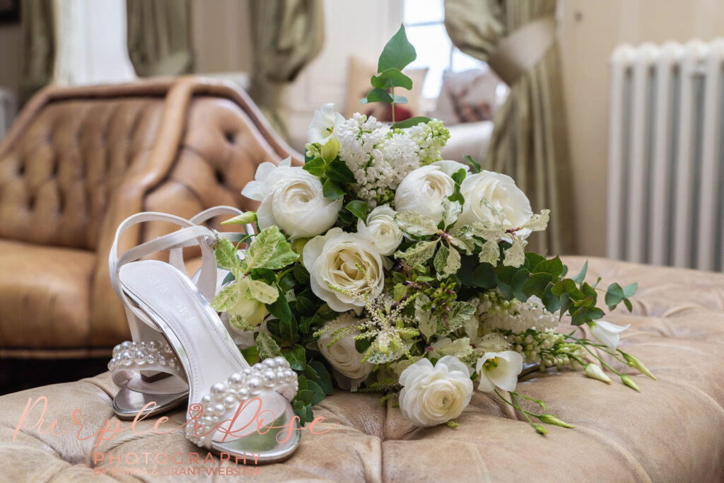 Photo of brides white wedding bouquet and shoes on her wedding day