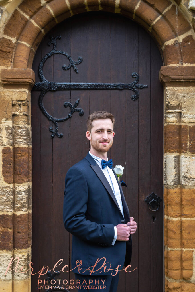 Photo of a groom outisde the church door on his weding day in Bedford