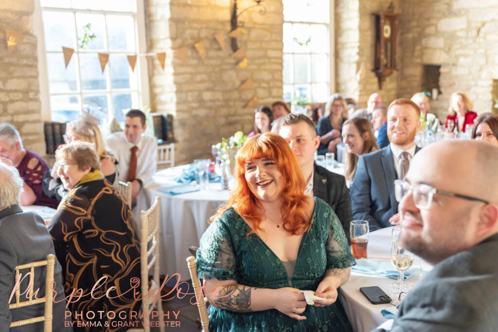 Photo of a wedding guest laughing during the speaches at a wedding in Milton Keynes