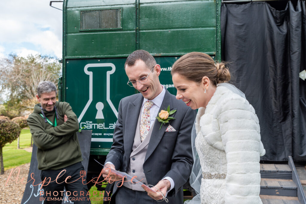 Photo of bride and groom reading lcues to an escape room on their wedding day in Milton Keynes